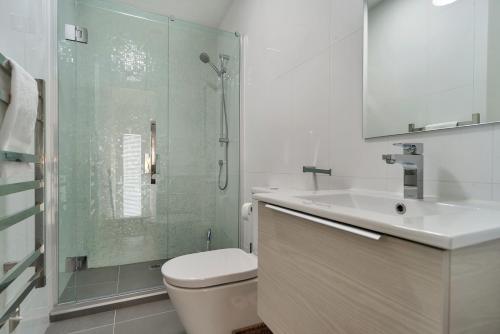 a bathroom with a shower and a toilet and a sink at QV Modern 3 Level Sunny Townhouse (640) in Auckland