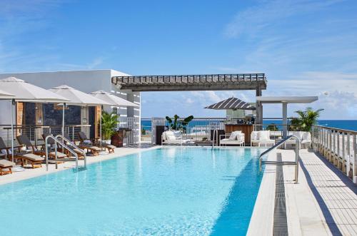 - une piscine au sommet d'un bâtiment avec l'océan en arrière-plan dans l'établissement The Betsy Hotel, South Beach, à Miami Beach