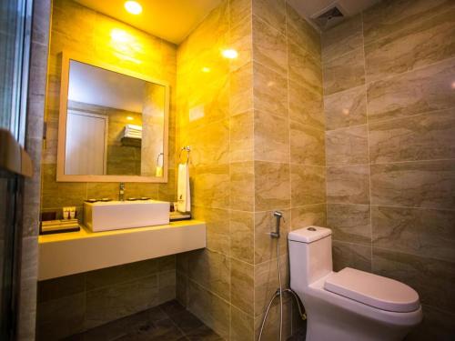 a bathroom with a toilet and a sink and a mirror at Austin Park Hotel in Johor Bahru