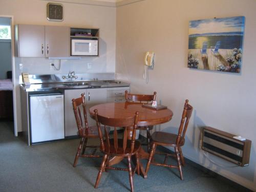 a kitchen with a table and chairs in a room at Blue Dolphin Motel in Timaru