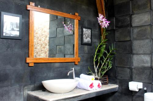 een badkamer met een wastafel en een spiegel bij Morning Bali Bungalow in Canggu