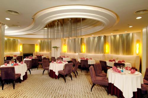 comedor con mesas y sillas y techo en Grandview Hotel Macau en Macao