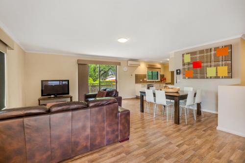 a living room with a couch and a dining room at National Hotel Complex Bendigo in Bendigo