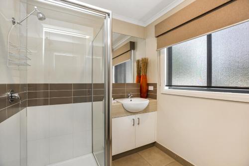 a bathroom with a glass shower and a sink at National Hotel Complex Bendigo in Bendigo