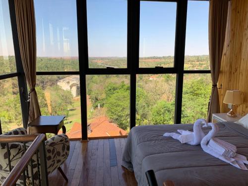 a bedroom with a bed and a large window at NatuCenter Hospedaje in Puerto Presidente Franco