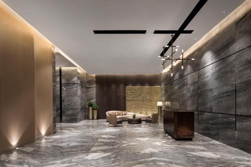 a lobby with a couch and a fireplace at Ascott Songshan Lake Dongguan in Dongguan