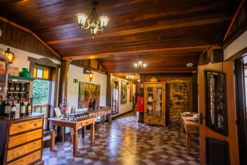 a room with wooden ceilings and a bar with tables at Tiradentes Village in Tiradentes