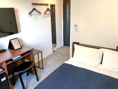 a hotel room with a bed and a desk and a computer at HOTEL LiVEMAX Chiba Soga-Ekimae in Chiba