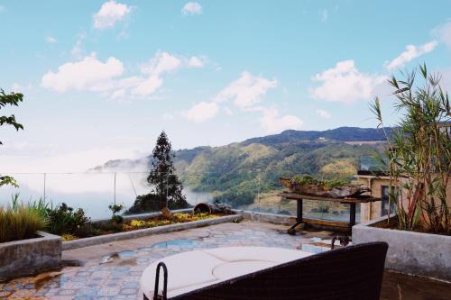 a patio with a view of the water and mountains at The Twelve Manor•Terraces Lodge in Yuanyang