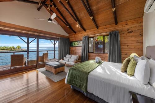 a bedroom with a large bed and a living room at Aga Reef Resort and Spa in Lalomanu