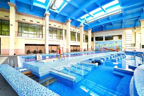 a large swimming pool with blue tiles in a building at Tongli Lake View Hotel in Suzhou