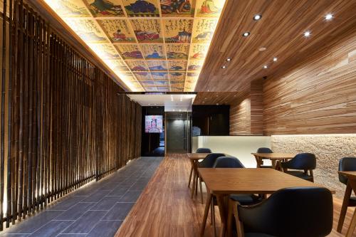 a restaurant with wooden walls and tables and chairs at Carta Hotel Kyoto Bettei in Kyoto
