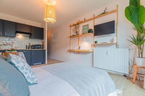une chambre avec un grand lit et une cuisine dans l'établissement Studio Bali 2** + Parking Privé inclus, à Aix-les-Bains