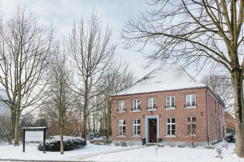 um grande edifício de tijolos vermelhos na neve em Altes Pfarrhaus em Geldern