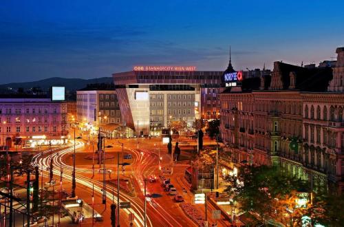 a city skyline at night with traffic on a street at Hotel Corvinus Vienna in Vienna
