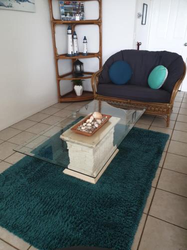 a living room with a couch and a glass table at Bayview Harbourview Apartments in Mooloolaba