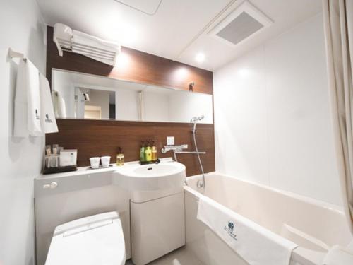 a bathroom with a white toilet and a sink at HOTEL LiVEMAX Asakusa-Ekimae in Tokyo