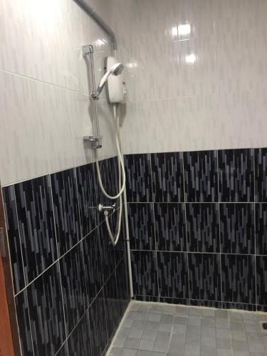 a shower in a bathroom with black and white tile at Aladdin Guest House in Phi Phi Don