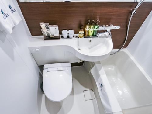 ein Badezimmer mit einem WC, einem Waschbecken und einer Badewanne in der Unterkunft HOTEL LiVEMAX BUDGET Fuji Ekimae in Fuji