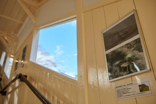 a window on a wall with a picture on it at Nipponia Hotel Koyasan Pilgrimage Railway - In the station Inn - Self Check-In Only in Kudoyama