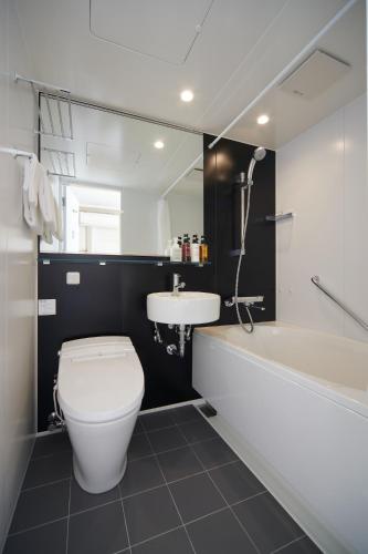 a bathroom with a toilet and a sink and a tub at Nipponia Hotel Koyasan Pilgrimage Railway - In the station Inn - Self Check-In Only in Kudoyama