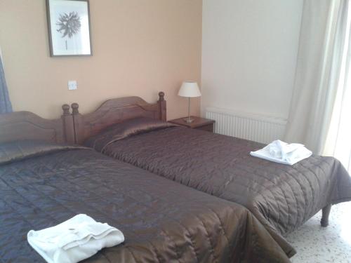two beds in a hotel room with towels on them at Hill View Hotel Apartments in Pissouri