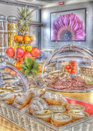 a display case with various types of food on a table at Executive Hotel in Forlì