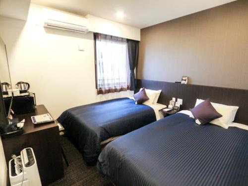 Tempat tidur dalam kamar di HOTEL LiVEMAX Shinjuku EAST