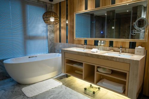 a bathroom with a tub, toilet and sink at arTree hotel in Taipei