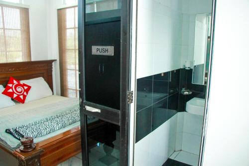 a bathroom with a shower and a bed in a room at White House in Wattala
