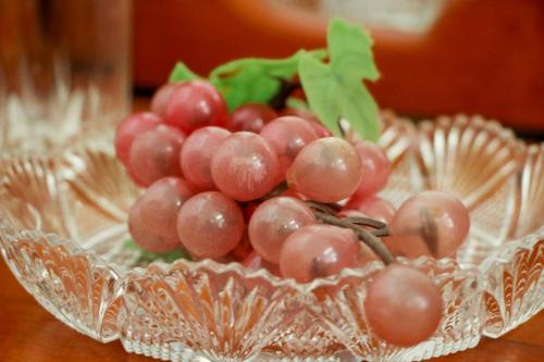 a bunch of grapes in a glass bowl on a table at White House in Wattala