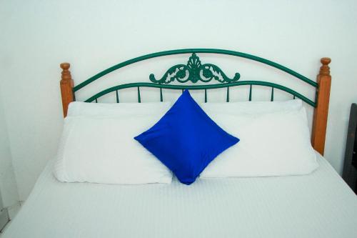 a blue pillow sitting on top of a bed at White House in Wattala