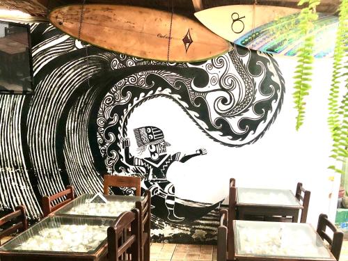 a room with a surfboard painted on the wall at Surf hostel My Friends in Huanchaco