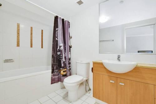 a bathroom with a toilet and a sink and a tub at 1 Bedroom - Private Managed Resort Pool and Beach - Alex in Maroochydore