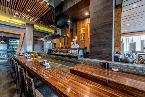 a man standing behind a counter in a restaurant at Holiday Inn Cikarang Jababeka by IHG in Cikarang