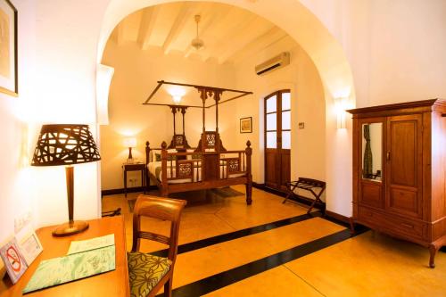 a living room with a desk and a table with a lamp at Palais De Mahe - A CGH Earth Experience in Puducherry