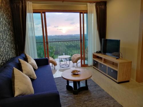 a living room with a blue couch and a television at Khaolak Blue Sky Villa in Khao Lak