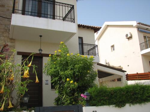 a white house with a door and a bush at Hill View Hotel Apartments in Pissouri
