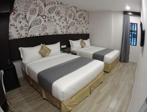八打靈再也的住宿－Hotel MM @ Sunway，一间卧室设有两张床和一堵墙