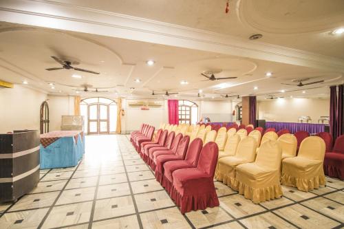 a room with red and yellow chairs and a stage at WOW STAYZ2 Hotel Jahanvi Dale in Haridwār