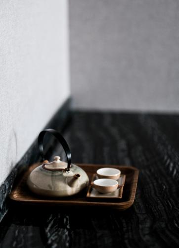 a tea kettle and two cups on a tray at The Luzerne Hotel in Dehua