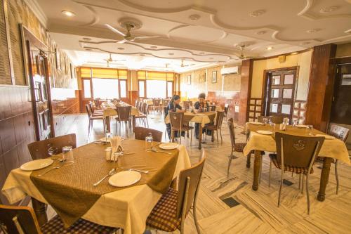 a restaurant with tables and chairs with people sitting at them at WOW STAYZ2 Hotel Jahanvi Dale in Haridwār