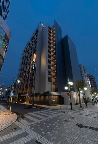 a tall building in the middle of a city at Dormy Inn Kawasaki Natural Hot Spring in Kawasaki