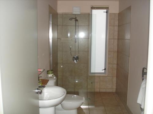 a bathroom with a shower and a toilet and a sink at Parkside Motel in Richmond