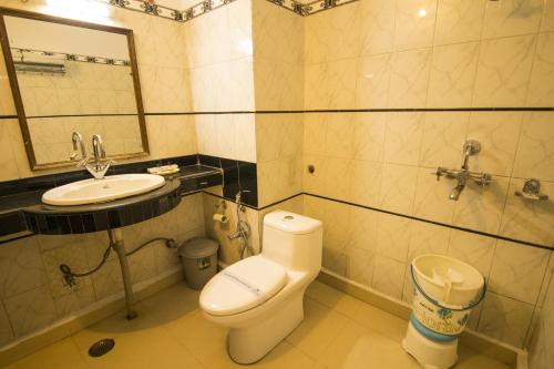 a bathroom with a toilet and a sink and a mirror at WOW STAYZ2 Hotel Jahanvi Dale in Haridwār