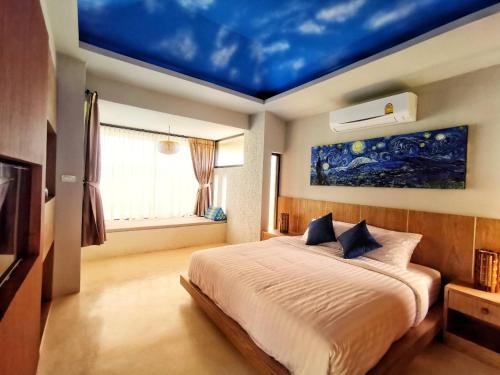 a bedroom with a bed with a blue ceiling at Hideaway in Chiang Mai