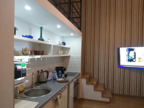 a kitchen with a sink and a tv at Tempo Life Apartman in Budapest