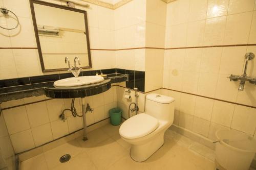 a bathroom with a toilet and a sink and a mirror at WOW STAYZ2 Hotel Jahanvi Dale in Haridwār