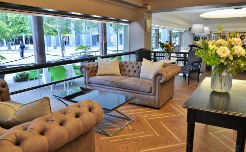 a living room with couches and a table with flowers at The Capetonian - Halal in Cape Town