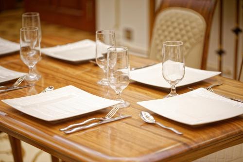 a wooden table with empty wine glasses and napkins at Royal Swiss Lahore in Lahore
